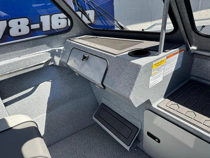 Slide: The Image of 2024 KingFisher 1825 Falcon boat interior with storage compartments and cup holder. - 23