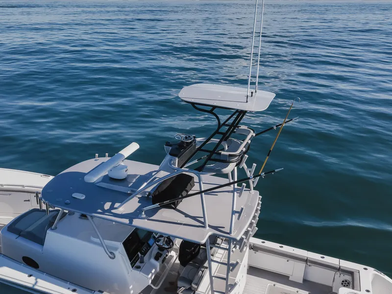 Slide: The Image of 2019 Buddy Davis 42 CC boat on calm ocean waters, featuring a sleek design and fishing equipment. - 13