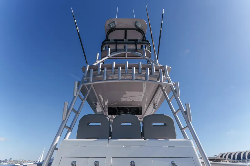 Slide: The Image of 2019 Buddy Davis 42 CC boat with fishing rods and tower against clear blue sky. - 16
