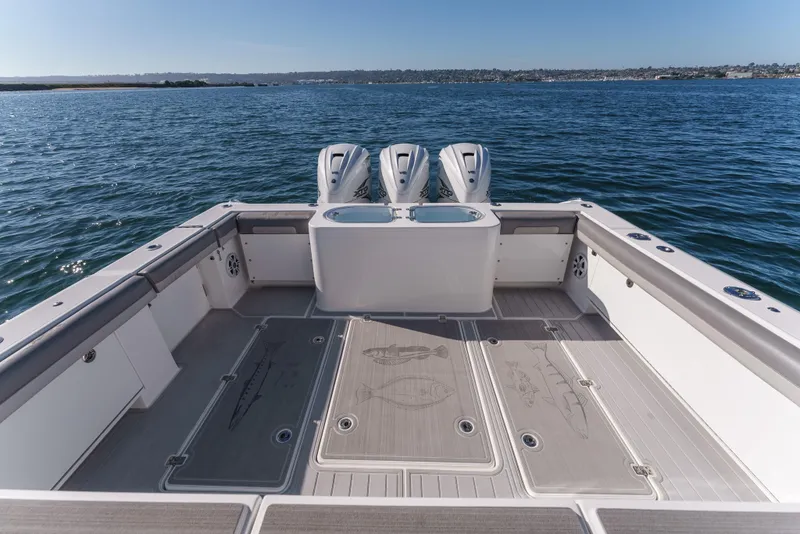 Slide: The Image of 2019 Buddy Davis 42 CC boat deck with triple outboard engines on open water. - 17