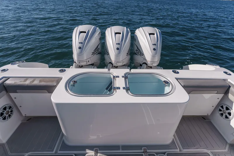 Slide: The Image of 2019 Buddy Davis 42 CC boat with triple outboard engines on open water. - 19