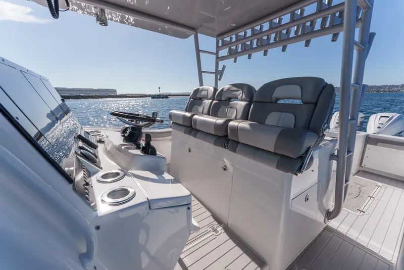 Slide: The Image of 2019 Buddy Davis 42 CC boat interior with helm and seating, on open water. - 20