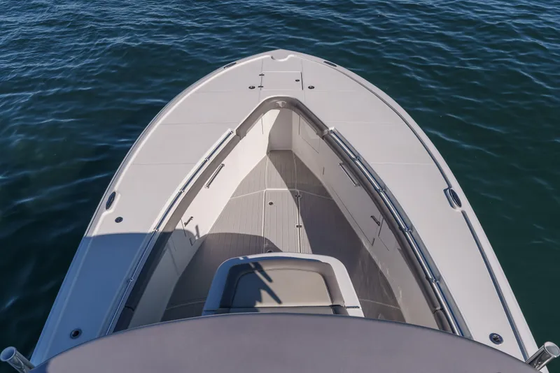 Slide: The Image of 2019 Buddy Davis 42 CC boat bow on calm water, showcasing sleek design and spacious deck. - 26