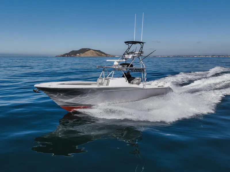 Slide: The Image of 2019 Buddy Davis 42 CC boat cruising on open water with distant island view. - 4