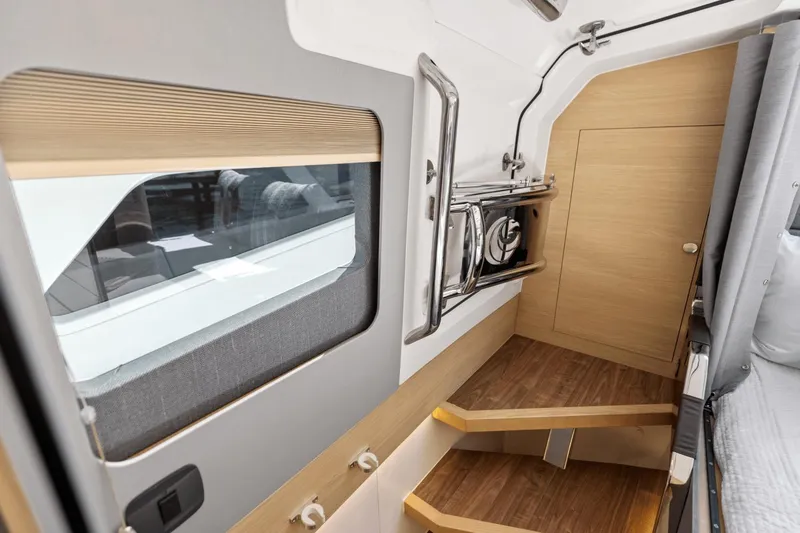 Slide: The Image of Interior of 2024 Aquila 47 Molokai boat with wooden steps and window. - 21