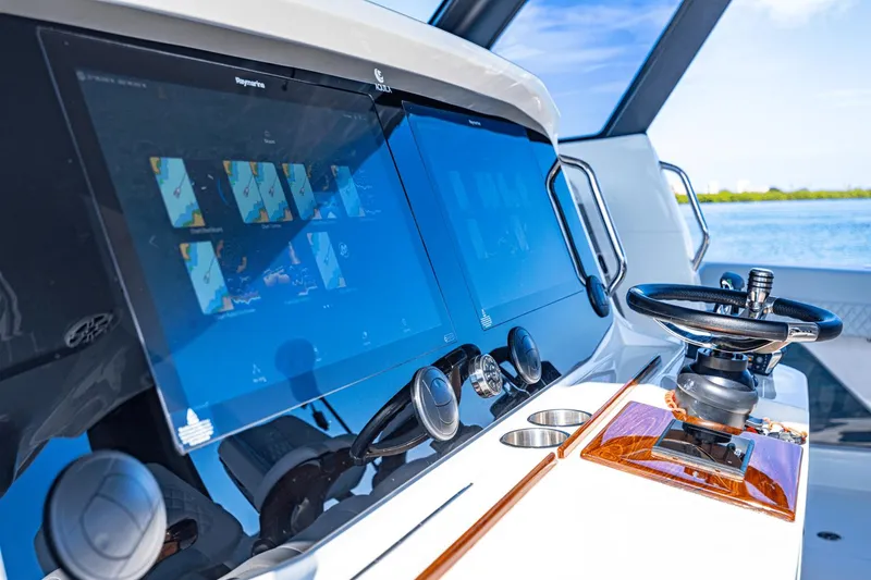Slide: The Image of Control panel of 2024 Aquila 47 Molokai with dual touchscreens and steering wheel. - 26