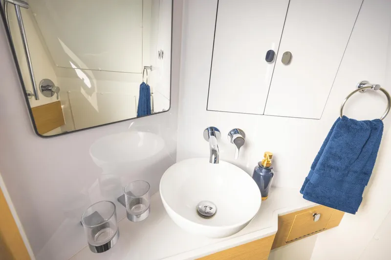 Slide: The Image of Modern bathroom sink in 2024 Aquila 47 Molokai yacht with mirror and blue towel. - 9