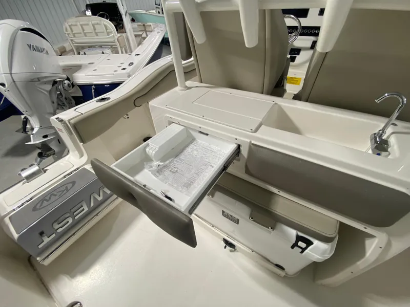 Slide: The Image of 2024 Key West 263 FS boat interior with storage compartments and Yamaha engine. - 11