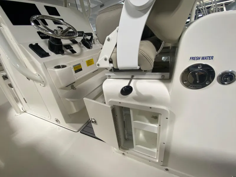 Slide: The Image of 2024 Key West 263 FS boat interior with steering console and fresh water compartment. - 13