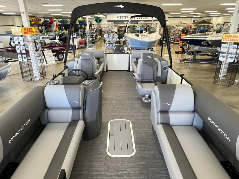 Slide: The Image of 2024 Bennington S Line boat interior in showroom, featuring gray seating and modern design. - 5
