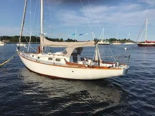 The Image of 1966 Tripp 31 Masthead Sloop sailboat anchored on calm water under a clear sky. - 0