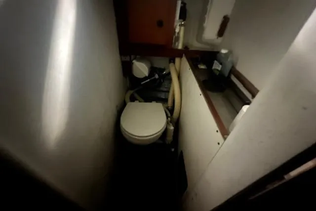 Slide: The Image of Compact bathroom in 1966 Tripp 31 Masthead Sloop sailboat, featuring toilet and storage space. - 10