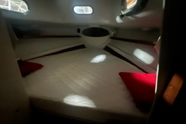 Slide: The Image of Cozy cabin interior of 1966 Tripp 31 Masthead Sloop with red pillows and natural light. - 11