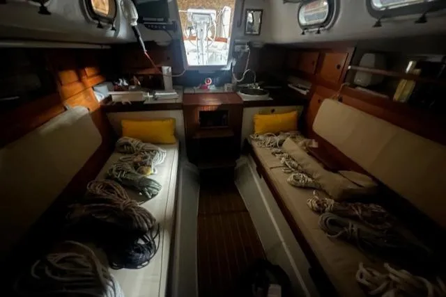 Slide: The Image of Interior of 1966 Tripp 31 Masthead Sloop with ropes and cushions on benches. - 12