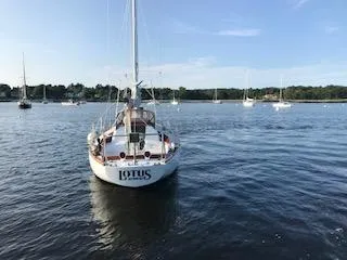 Slide: The Image of 1966 Tripp 31 Masthead Sloop sailboat on calm water, surrounded by other boats. - 2