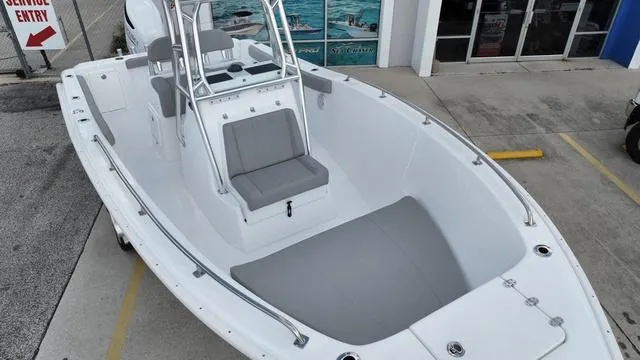 Slide: The Image of 2024 Cape Horn 22OS boat with gray seating, docked near a service entry. - 13