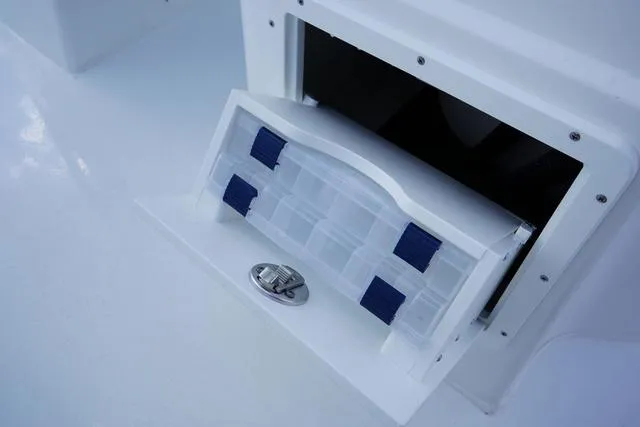 Slide: The Image of 2024 Cape Horn 22OS boat storage compartment with a pull-out drawer. - 49