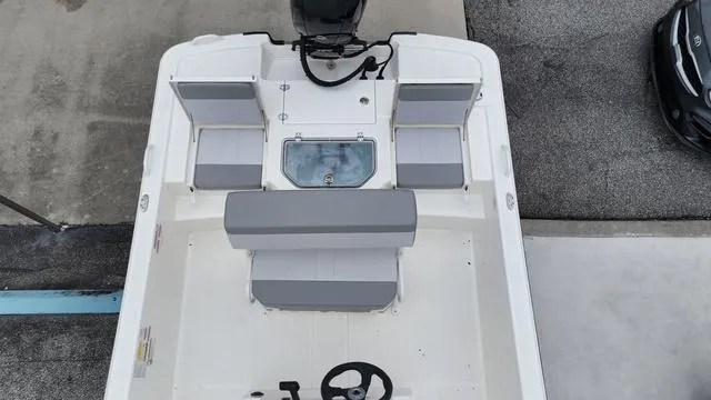 Slide: The Image of 2023 Mako 19 Pro Skiff boat interior with seating and steering console. - 16