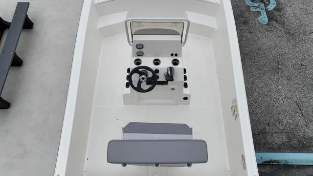 Slide: The Image of 2023 Mako 19 Pro Skiff boat interior with steering console and seating. - 17