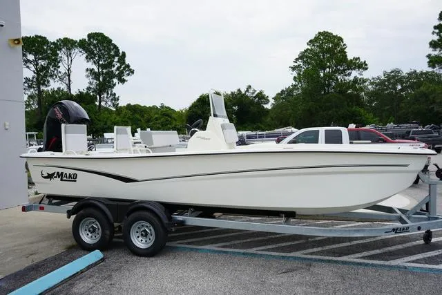 Slide: The Image of 2023 Mako 19 Pro Skiff boat on a trailer in a parking lot. - 19