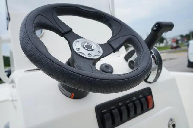 Slide: The Image of Close-up of the steering wheel and controls of a 2023 Mako 19 Pro Skiff boat. - 41