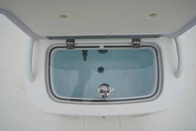 Slide: The Image of 2023 Mako 19 Pro Skiff livewell with open lid, showcasing interior. - 47