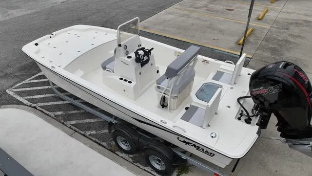 Slide: The Image of 2023 Mako 19 Pro Skiff boat on trailer, featuring center console and outboard motor. - 7