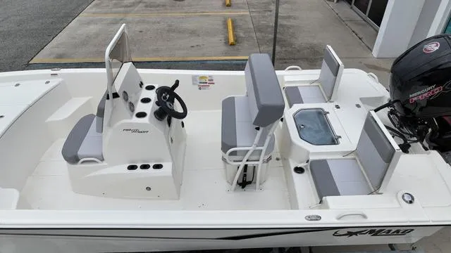 Slide: The Image of 2023 Mako 19 Pro Skiff boat with seating and console, docked. - 8