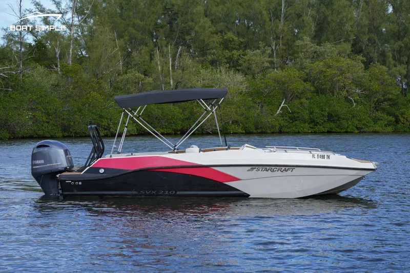 Slide: The Image of 2023 Starcraft SVX 210 OB boat on water with lush green background. - 3