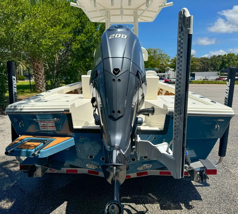 Slide: The Image of 2025 Pathfinder 2200 TRS boat with powerful outboard motor, parked outdoors. - 2