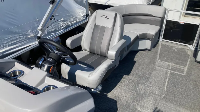 Slide: The Image of 2024 Bennington 21 SXSRC boat interior with captain's chair and curved seating. - 4