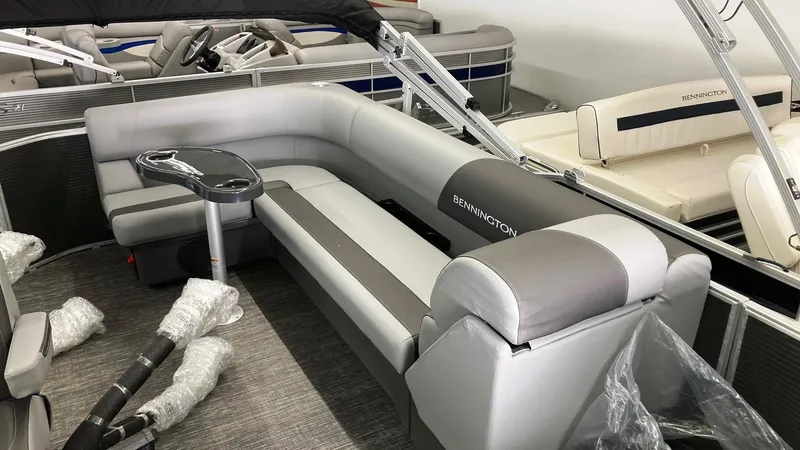 Slide: The Image of 2024 Bennington 20 SVL pontoon boat interior with gray seating and table. - 3