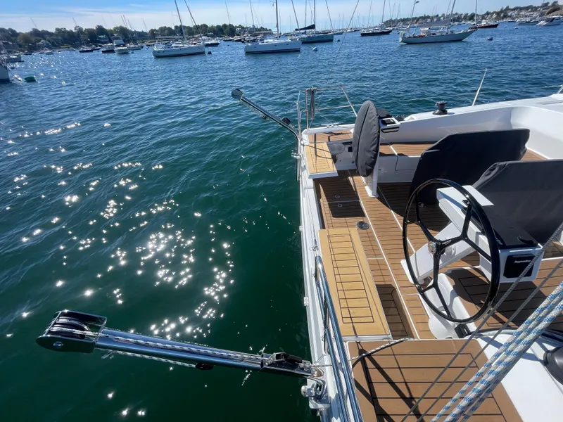 Slide: The Image of 2024 Hanse 410 yacht deck with steering wheel, overlooking a serene marina. - 15