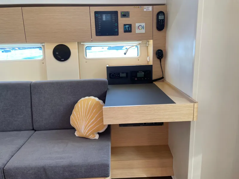 Slide: The Image of 2024 Hanse 410 yacht interior with sofa, shell pillow, and control panel. - 18