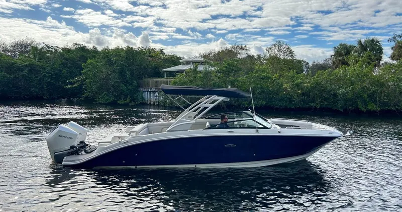 Slide: The Image of 2023 Sea Ray SDX 290 Outboard boat cruising on a scenic river. - 0