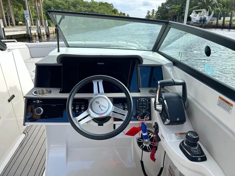 Slide: The Image of 2023 Sea Ray SDX 290 Outboard helm with modern controls and waterfront view. - 13
