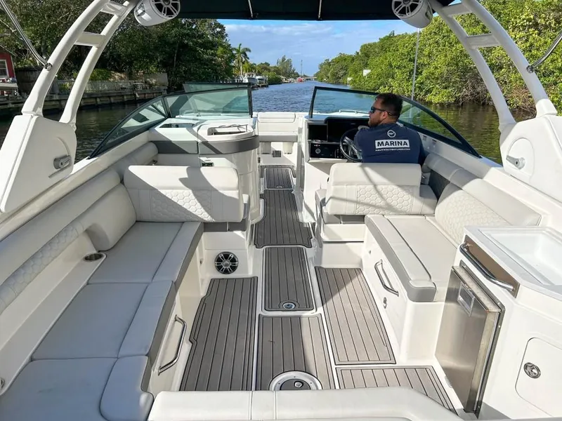 Slide: The Image of 2023 Sea Ray SDX 290 Outboard boat interior with captain navigating a canal. - 15