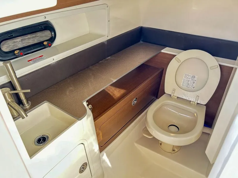 Slide: The Image of 2023 Sea Ray SDX 290 Outboard boat interior bathroom with sink and toilet. - 16