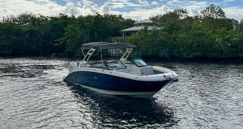 Slide: The Image of 2023 Sea Ray SDX 290 Outboard boat cruising on a calm river. - 4