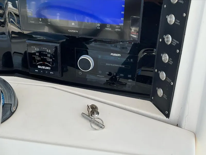 Slide: The Image of 2004 Venture 34 Center Console dashboard with Garmin, Suzuki, and Fusion electronics. - 10