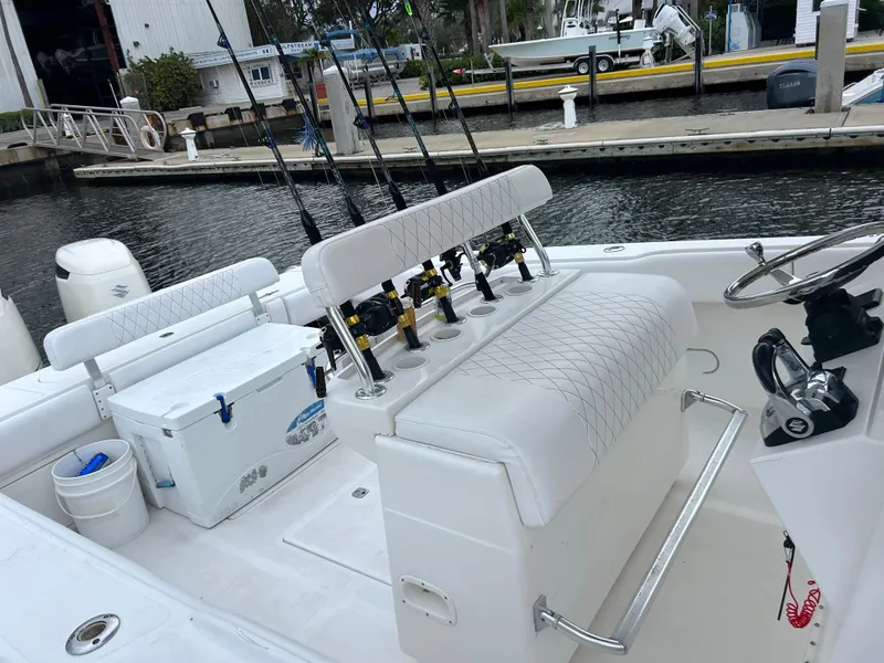 Slide: The Image of 2004 Venture 34 Center Console boat with fishing rods and cooler at dock. - 4