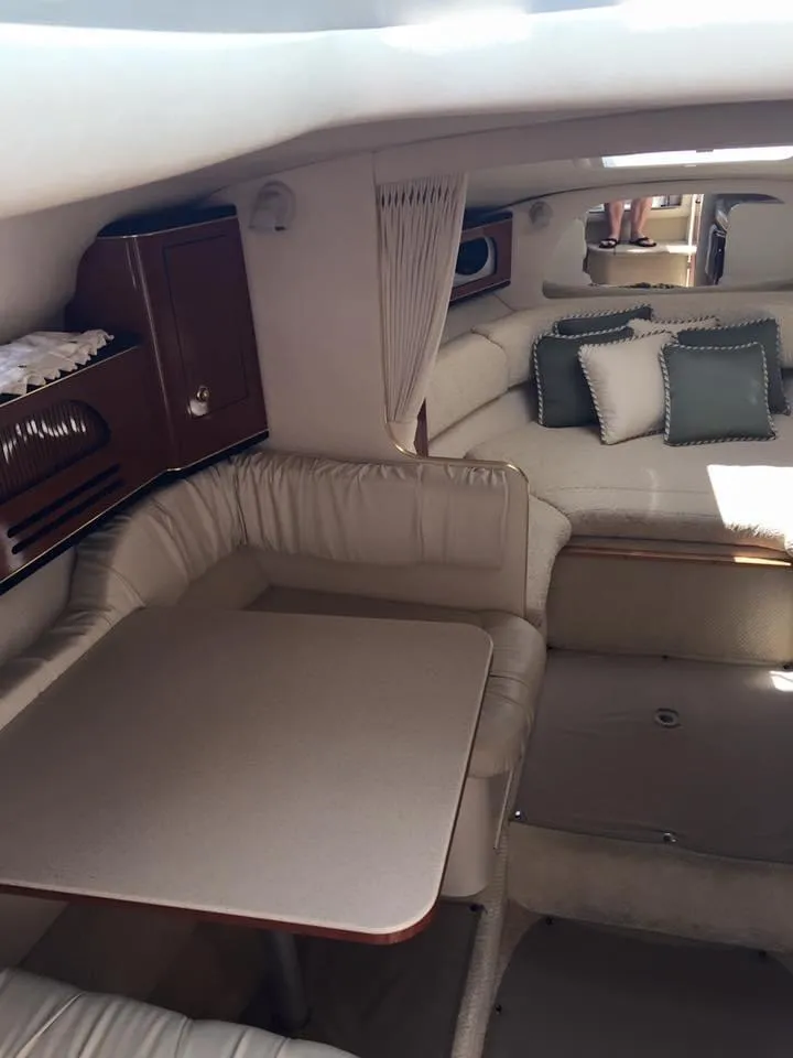 Slide: The Image of 2001 Sea Ray 280 Sundancer cabin interior with seating, table, and cushions. - 12