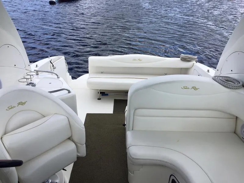 Slide: The Image of 2001 Sea Ray 280 Sundancer boat interior with white seating and water view. - 13