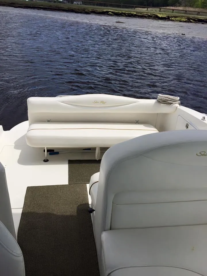 Slide: The Image of 2001 Sea Ray 280 Sundancer boat interior with white seating, overlooking calm water. - 14