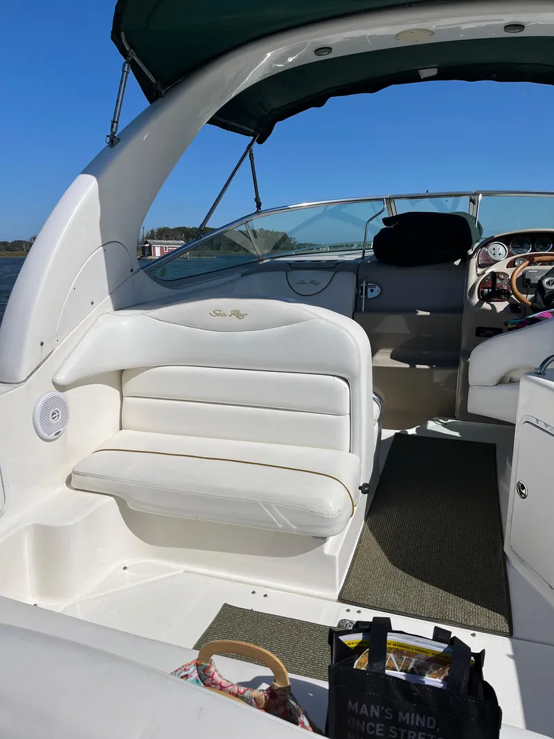 Slide: The Image of 2001 Sea Ray 280 Sundancer boat interior with white seating and green canopy. - 16