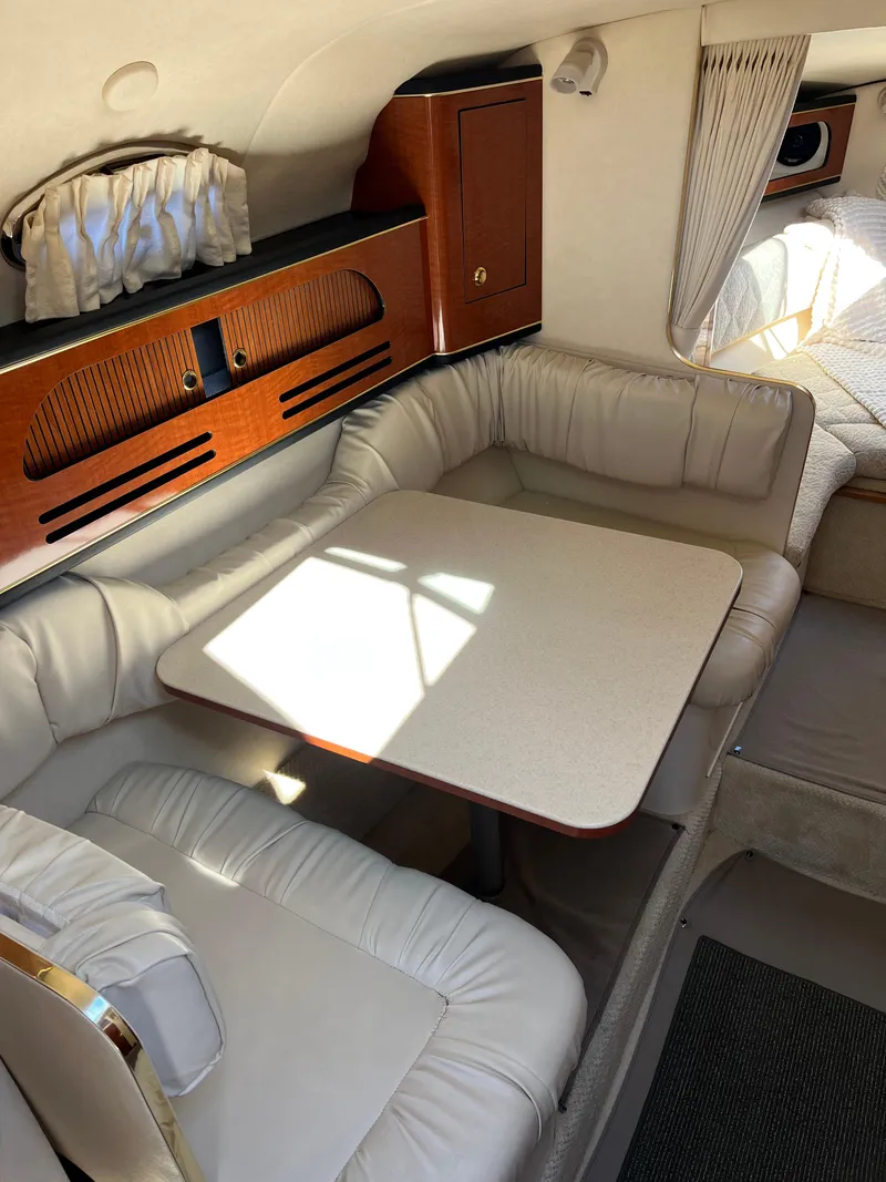 Slide: The Image of 2001 Sea Ray 280 Sundancer cabin with dining area and cozy seating. - 18