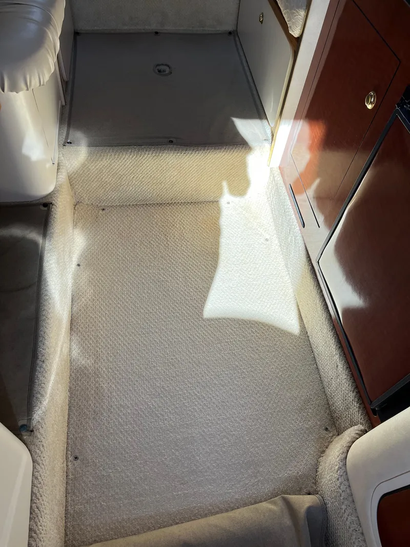 Slide: The Image of Interior view of 2001 Sea Ray 280 Sundancer, featuring carpeted flooring and wooden cabinetry. - 19