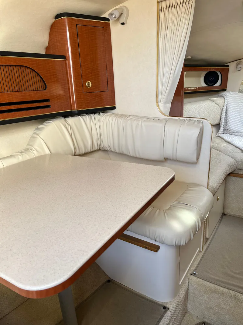Slide: The Image of Interior of 2001 Sea Ray 280 Sundancer with cushioned seating and wooden cabinetry. - 22