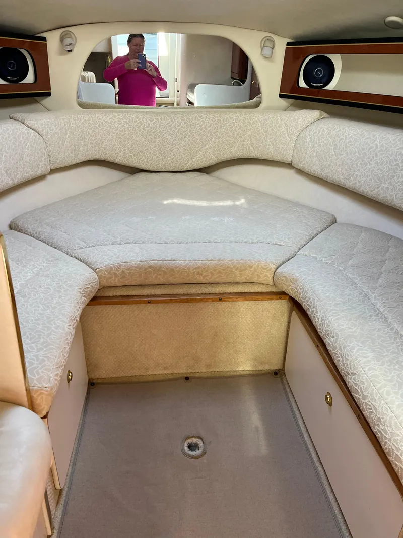 Slide: The Image of 2001 Sea Ray 280 Sundancer cabin interior with cushioned seating and wood accents. - 26