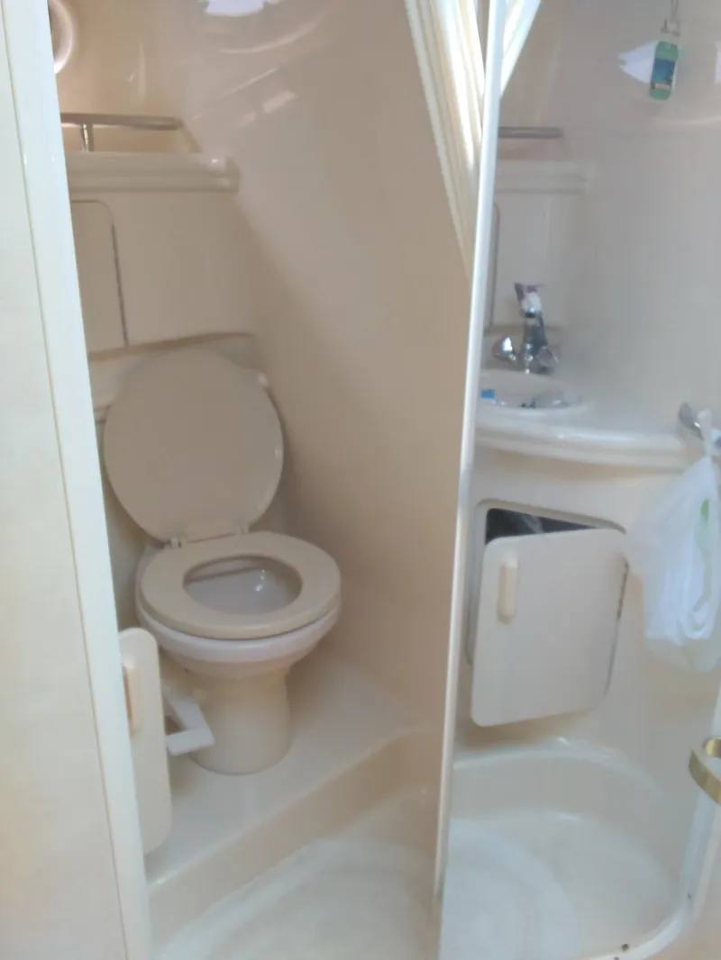 Slide: The Image of 2001 Sea Ray 280 Sundancer bathroom with toilet, sink, and shower. - 28